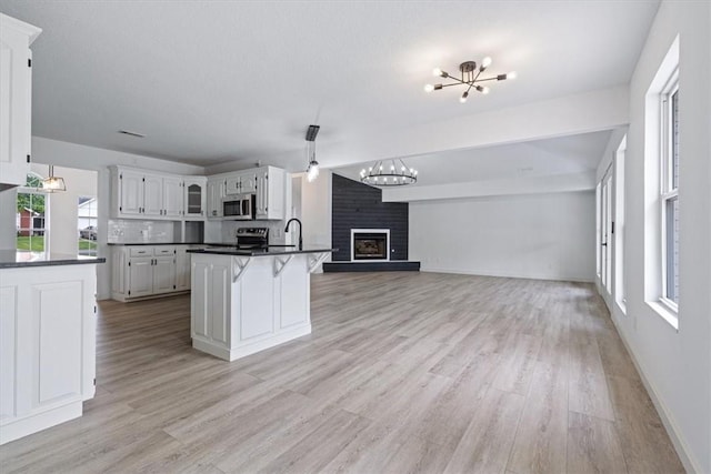119 Elm St, Centerton, AR 72719 - kitchen featuring stainless steel microwave, a chandelier, dark countertops, open floor plan, and a sink