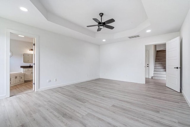 119 Elm St, Centerton, AR 72719 - unfurnished bedroom with a raised ceiling, recessed lighting, light wood finished floors, baseboards, and connected bathroom