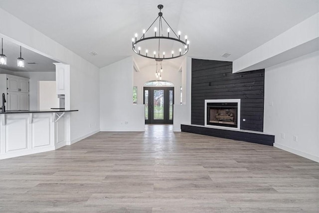 119 Elm St, Centerton, AR 72719 - unfurnished living room with lofted ceiling, a chandelier, baseboards, light wood-type flooring, and a large fireplace