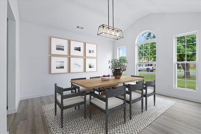 119 Elm St, Centerton, AR 72719 - dining room featuring wood finished floors, vaulted ceiling, baseboards, and a chandelier