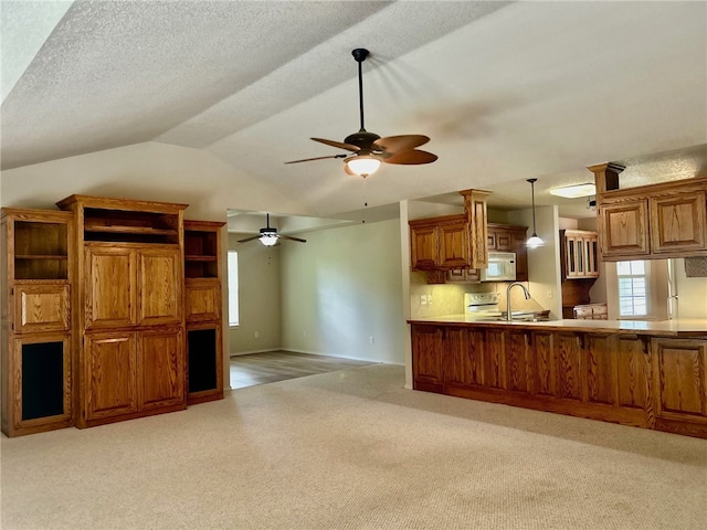 37 Retford Dr, Bella Vista, AR 72715 - kitchen featuring white microwave, a ceiling fan, light colored carpet, a sink, and brown cabinets