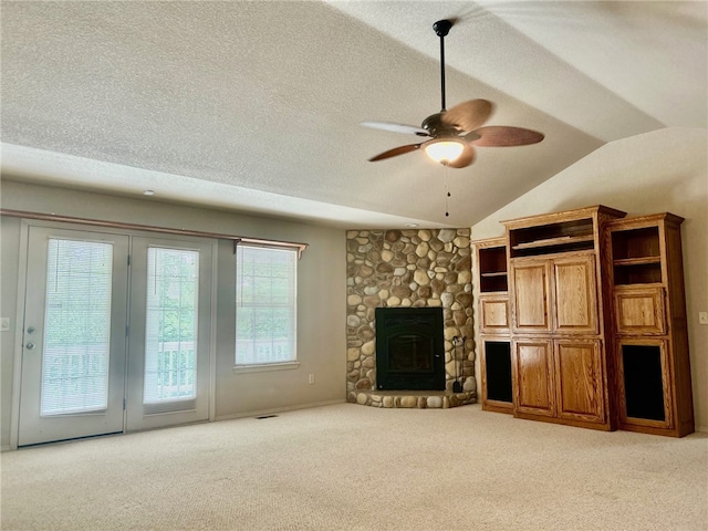 37 Retford Dr, Bella Vista, AR 72715 - unfurnished living room with ceiling fan, light colored carpet, vaulted ceiling, a textured ceiling, and a stone fireplace
