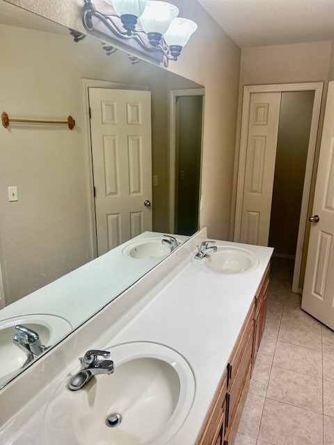 37 Retford Dr, Bella Vista, AR 72715 - bathroom with double vanity, tile patterned floors, and a chandelier