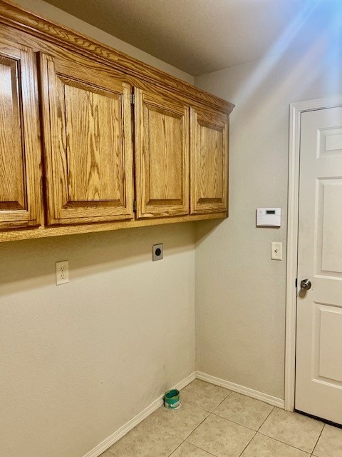 37 Retford Dr, Bella Vista, AR 72715 - laundry area featuring cabinet space, electric dryer hookup, baseboards, and light tile patterned floors