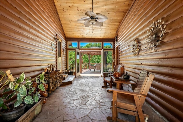 2895 County Road 116, Eureka Springs, AR 72631 - sunroom / solarium with log walls, ceiling fan, wood ceiling, and stone flooring