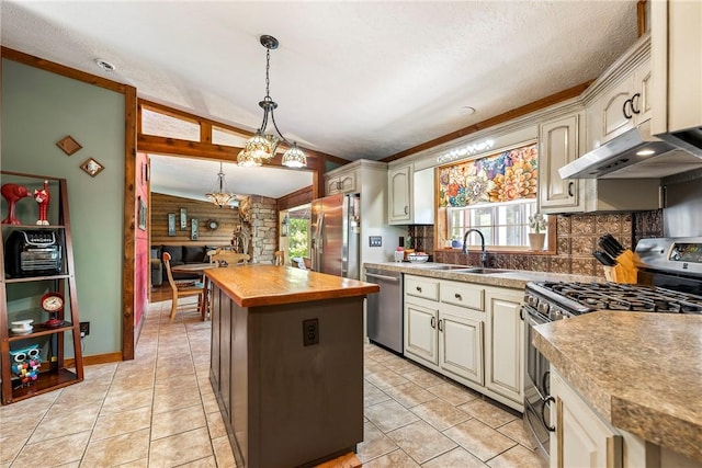 2895 County Road 116, Eureka Springs, AR 72631 - kitchen featuring appliances with stainless steel finishes, a center island, cream cabinetry, under cabinet range hood, and wood counters