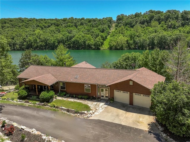 2895 County Road 116, Eureka Springs, AR 72631 - view of front of property with french doors, an attached garage, a view of trees, driveway, and a water view