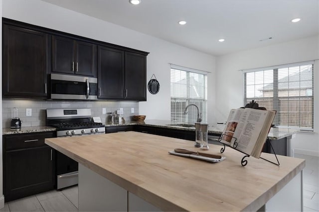 600 Gala Cir, Bentonville, AR 72712 - kitchen featuring appliances with stainless steel finishes, wood counters, backsplash, a sink, and recessed lighting