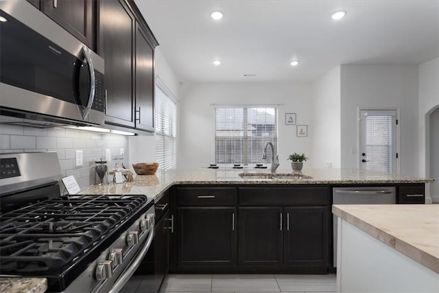600 Gala Cir, Bentonville, AR 72712 - kitchen featuring appliances with stainless steel finishes, a sink, tasteful backsplash, light stone counters, and recessed lighting
