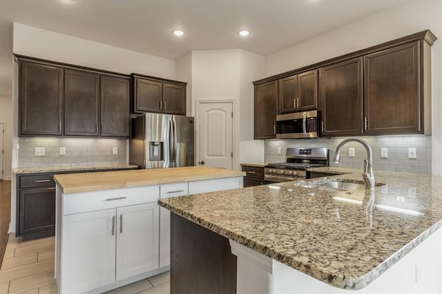600 Gala Cir, Bentonville, AR 72712 - kitchen featuring stainless steel appliances, a sink, dark brown cabinetry, light stone counters, and recessed lighting