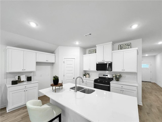 1661 Ridgeview Dr, Springdale, AR 72762 - kitchen featuring appliances with stainless steel finishes, a sink, light wood finished floors, white cabinets, and baseboards