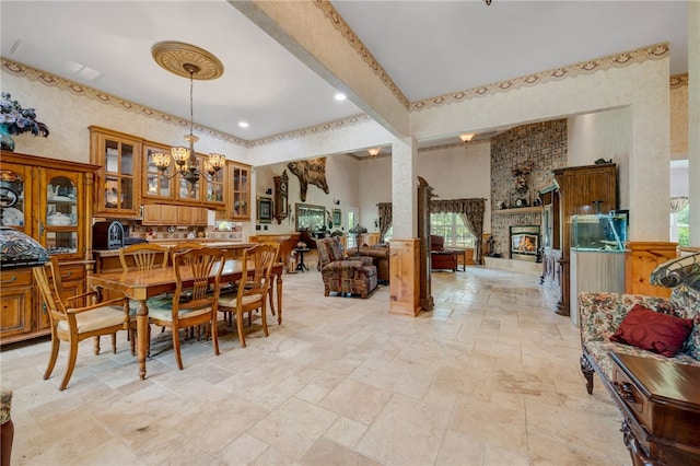 947 Cemetery Rd, Alma, AR 72921 - dining area featuring stone tile floors, a chandelier, a fireplace, a wainscoted wall, and a high ceiling