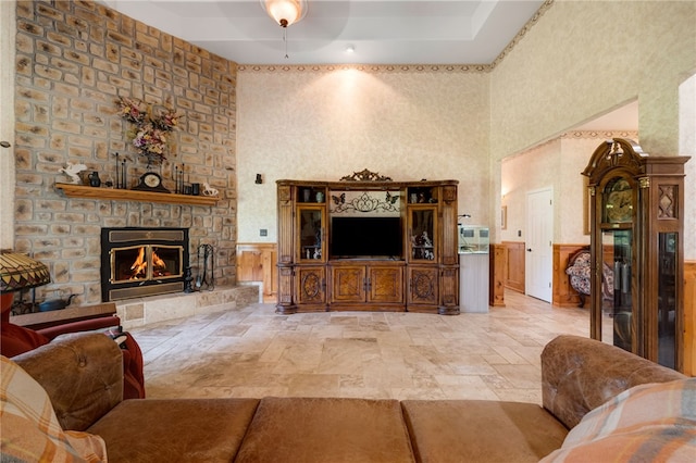 947 Cemetery Rd, Alma, AR 72921 - living area with a fireplace, stone tile floors, a towering ceiling, and wainscoting