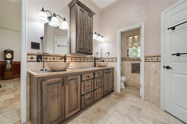 947 Cemetery Rd, Alma, AR 72921 - bathroom with toilet, double vanity, wainscoting, stone tile flooring, and tile walls