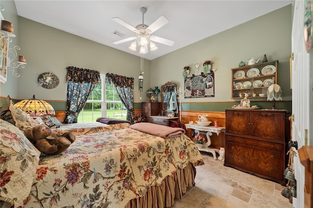 947 Cemetery Rd, Alma, AR 72921 - bedroom with stone finish flooring, a wainscoted wall, and a ceiling fan