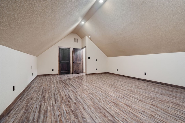 480124 E 1082nd Rd, Muldrow, OK 74948 - additional living space with wood finished floors, a textured ceiling, vaulted ceiling, and baseboards