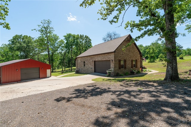 480124 E 1082nd Rd, Muldrow, OK 74948 - view of home's exterior with brick siding, an outbuilding, and a garage