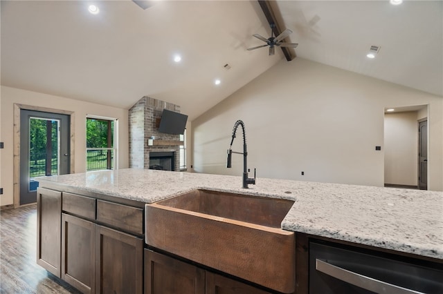 480124 E 1082nd Rd, Muldrow, OK 74948 - kitchen with a sink, ceiling fan, dishwasher, a brick fireplace, and dark brown cabinets
