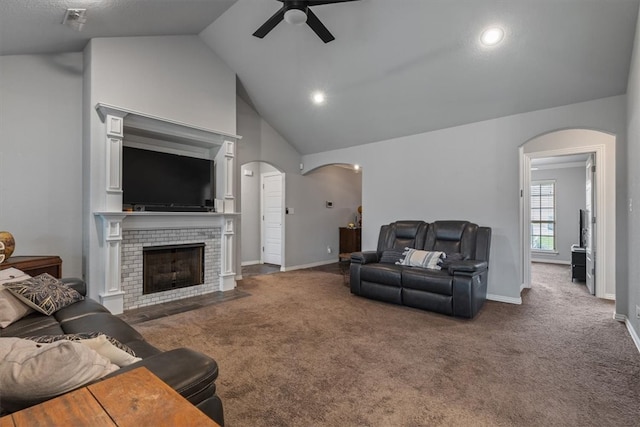 809 Dollar St, Cave Springs, AR 72718 - carpeted living area with arched walkways, a ceiling fan, a tile fireplace, baseboards, and high vaulted ceiling