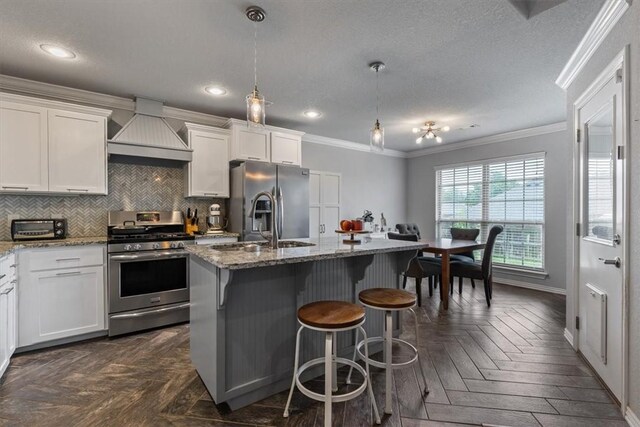 809 Dollar St, Cave Springs, AR 72718 - kitchen with appliances with stainless steel finishes, custom exhaust hood, crown molding, light stone countertops, and a center island with sink