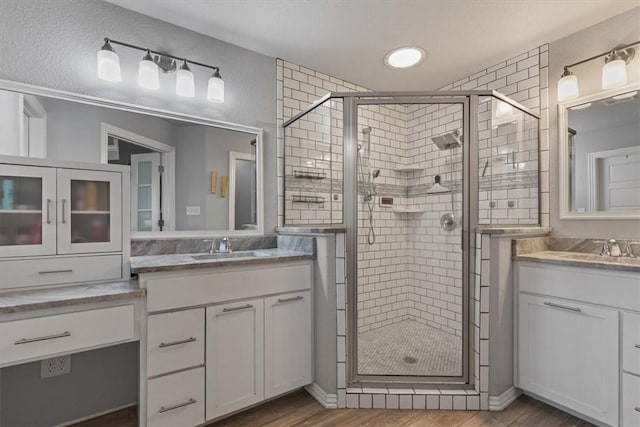 809 Dollar St, Cave Springs, AR 72718 - bathroom with a stall shower, two vanities, wood finished floors, and recessed lighting