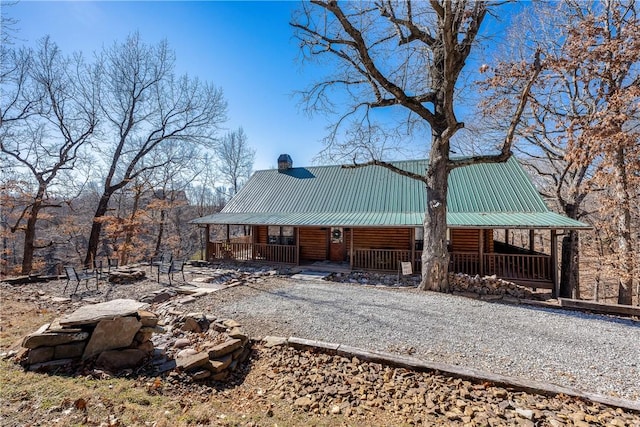 22283 N Log Cabin Dr, Sulphur Springs, AR 72768 - view of property exterior featuring a porch, metal roof, and a chimney