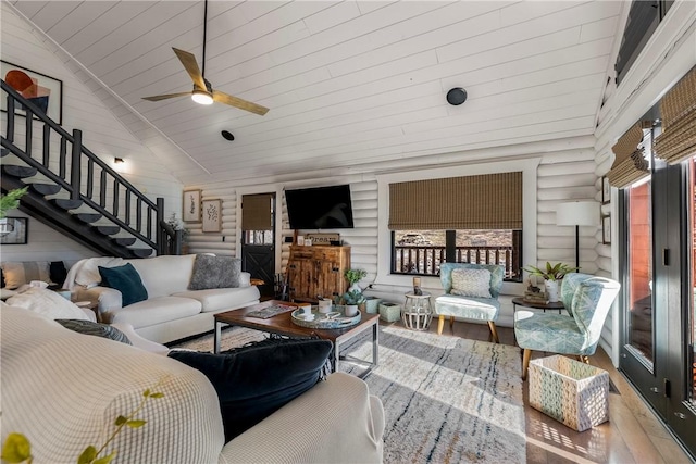 22283 N Log Cabin Dr, Sulphur Springs, AR 72768 - living area with wood finished floors, a ceiling fan, stairs, rustic walls, and lofted ceiling