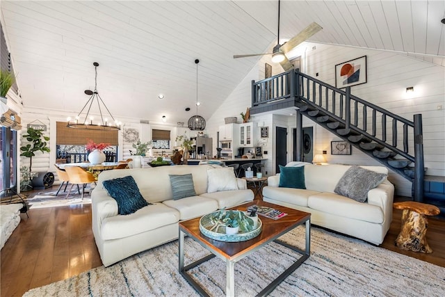 22283 N Log Cabin Dr, Sulphur Springs, AR 72768 - living area featuring wood-type flooring, high vaulted ceiling, stairs, a ceiling fan, and wooden walls