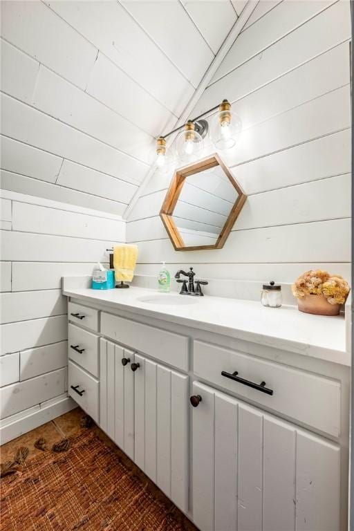 22283 N Log Cabin Dr, Sulphur Springs, AR 72768 - bathroom with vanity, vaulted ceiling, and wooden walls
