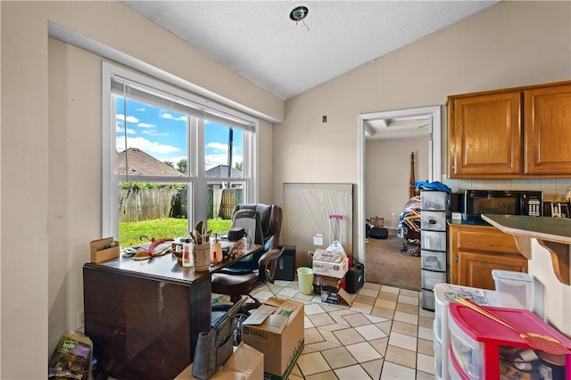 658 Walnut Ridge St, Centerton, AR 72719 - kitchen featuring vaulted ceiling, brown cabinetry, black microwave, light tile patterned floors, and a desk