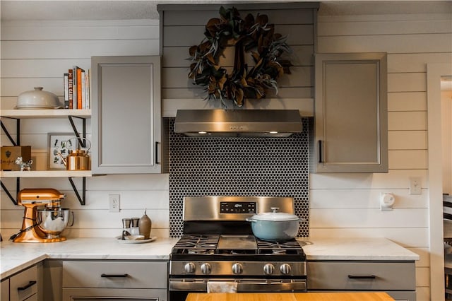 20608 Keck Rd, Siloam Springs, AR 72761 - kitchen featuring gray cabinets, gas range, under cabinet range hood, and wood walls