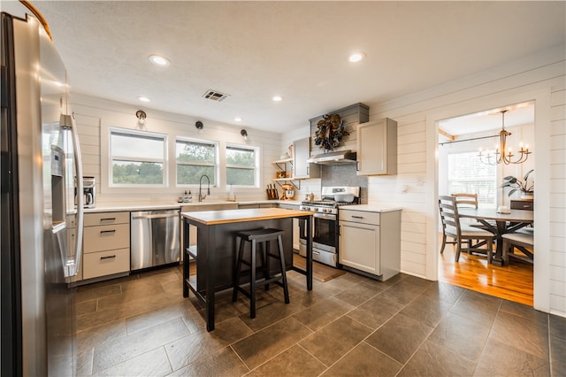 20608 Keck Rd, Siloam Springs, AR 72761 - kitchen with stainless steel appliances, under cabinet range hood, backsplash, light countertops, and a chandelier