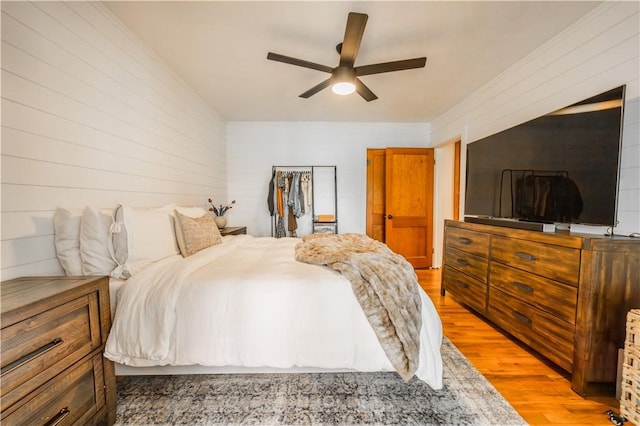 20608 Keck Rd, Siloam Springs, AR 72761 - bedroom featuring light wood-type flooring, wooden walls, and ceiling fan