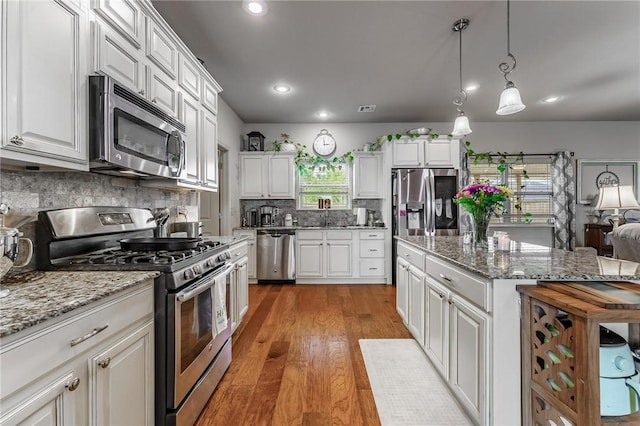 757 Harper Dr, Pea Ridge, AR 72751 - kitchen with appliances with stainless steel finishes, white cabinets, light wood finished floors, backsplash, and recessed lighting