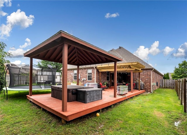 6401 S 42nd St, Rogers, AR 72758 - deck featuring a trampoline, a covered hot tub, a pergola, and a grill