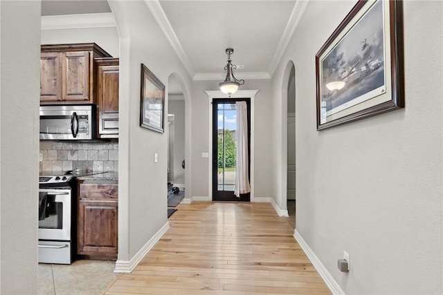 6401 S 42nd St, Rogers, AR 72758 - entryway with arched walkways, light wood-style floors, crown molding, and baseboards