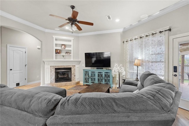 6401 S 42nd St, Rogers, AR 72758 - living area with ceiling fan, wood finished floors, built in shelves, arched walkways, and baseboards