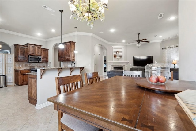 6401 S 42nd St, Rogers, AR 72758 - dining room with arched walkways, ceiling fan, recessed lighting, a fireplace, and light tile patterned flooring