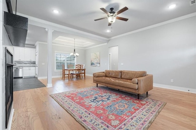 1265 Cassia, Tontitown, AR 72762 - living area featuring ceiling fan, a chandelier, baseboards, light wood-style floors, and crown molding