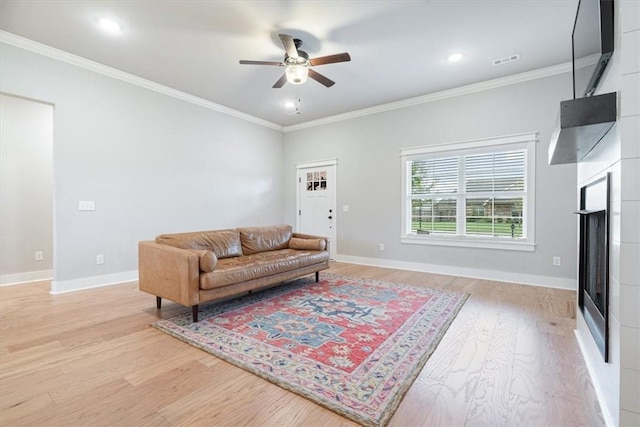 1265 Cassia, Tontitown, AR 72762 - living area featuring ceiling fan, light wood-style floors, ornamental molding, baseboards, and a glass covered fireplace