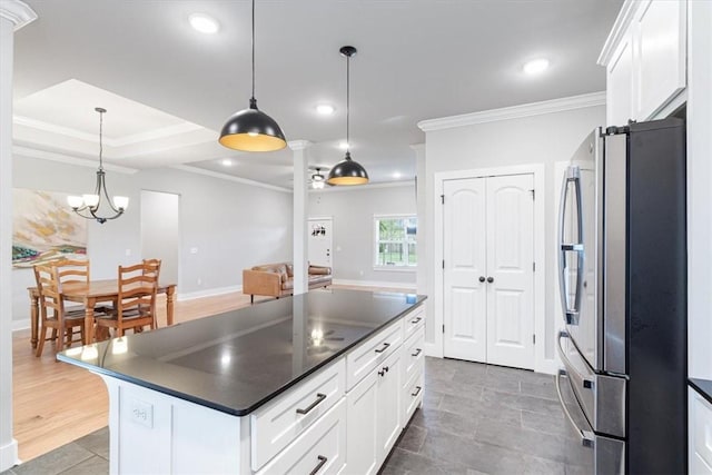 1265 Cassia, Tontitown, AR 72762 - kitchen with freestanding refrigerator, dark countertops, white cabinetry, crown molding, and a center island