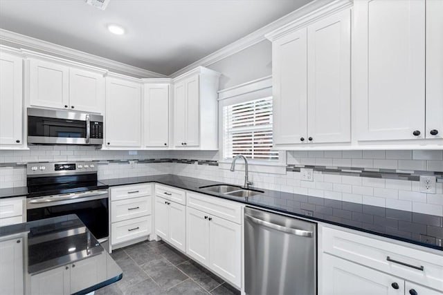 1265 Cassia, Tontitown, AR 72762 - kitchen featuring appliances with stainless steel finishes, a sink, dark countertops, white cabinets, and backsplash