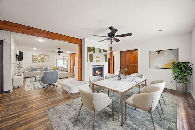 1149 Sunrise Ave, Springdale, AR 72764 - dining room featuring a ceiling fan, wood finished floors, a lit fireplace, beamed ceiling, and baseboards