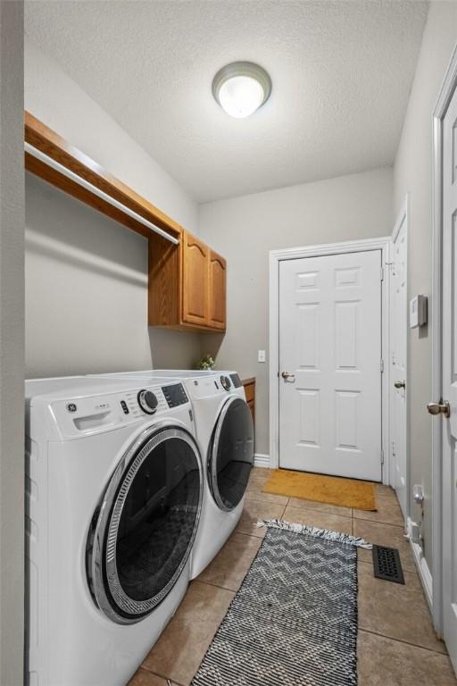 8200 Titleist Cir, Rogers, AR 72756 - washroom featuring independent washer and dryer, light tile patterned floors, a textured ceiling, and cabinet space