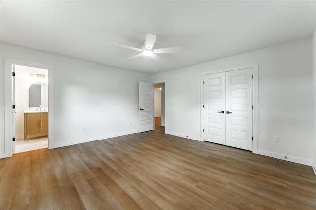 5479 Bob Mills Rd, Springdale, AR 72762 - unfurnished bedroom with wood finished floors, baseboards, ensuite bathroom, and a closet