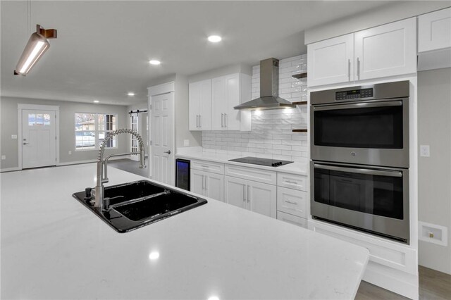 1115 Eicher Ave, Springdale, AR 72764 - kitchen featuring wall chimney exhaust hood, double oven, a sink, light countertops, and tasteful backsplash