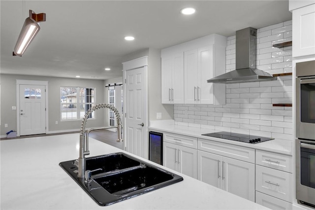 1115 Eicher Ave, Springdale, AR 72764 - kitchen featuring wall chimney range hood, black electric cooktop, a sink, beverage cooler, and decorative backsplash