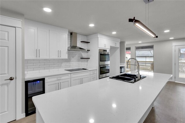 1115 Eicher Ave, Springdale, AR 72764 - kitchen with beverage cooler, wall chimney exhaust hood, stainless steel double oven, black electric stovetop, and a sink