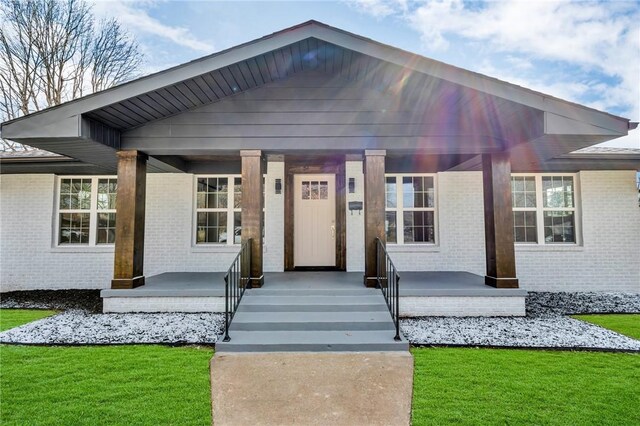 1115 Eicher Ave, Springdale, AR 72764 - view of front of home featuring a porch, brick siding, and a front yard