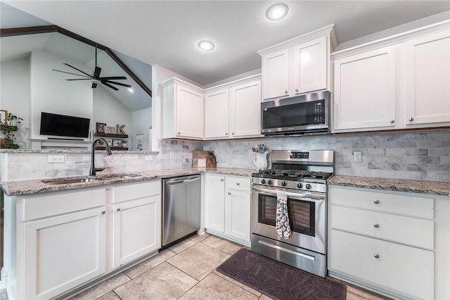 7533 Devonshire Ave, Springdale, AR 72762 - kitchen with stainless steel appliances, a sink, decorative backsplash, white cabinets, and vaulted ceiling